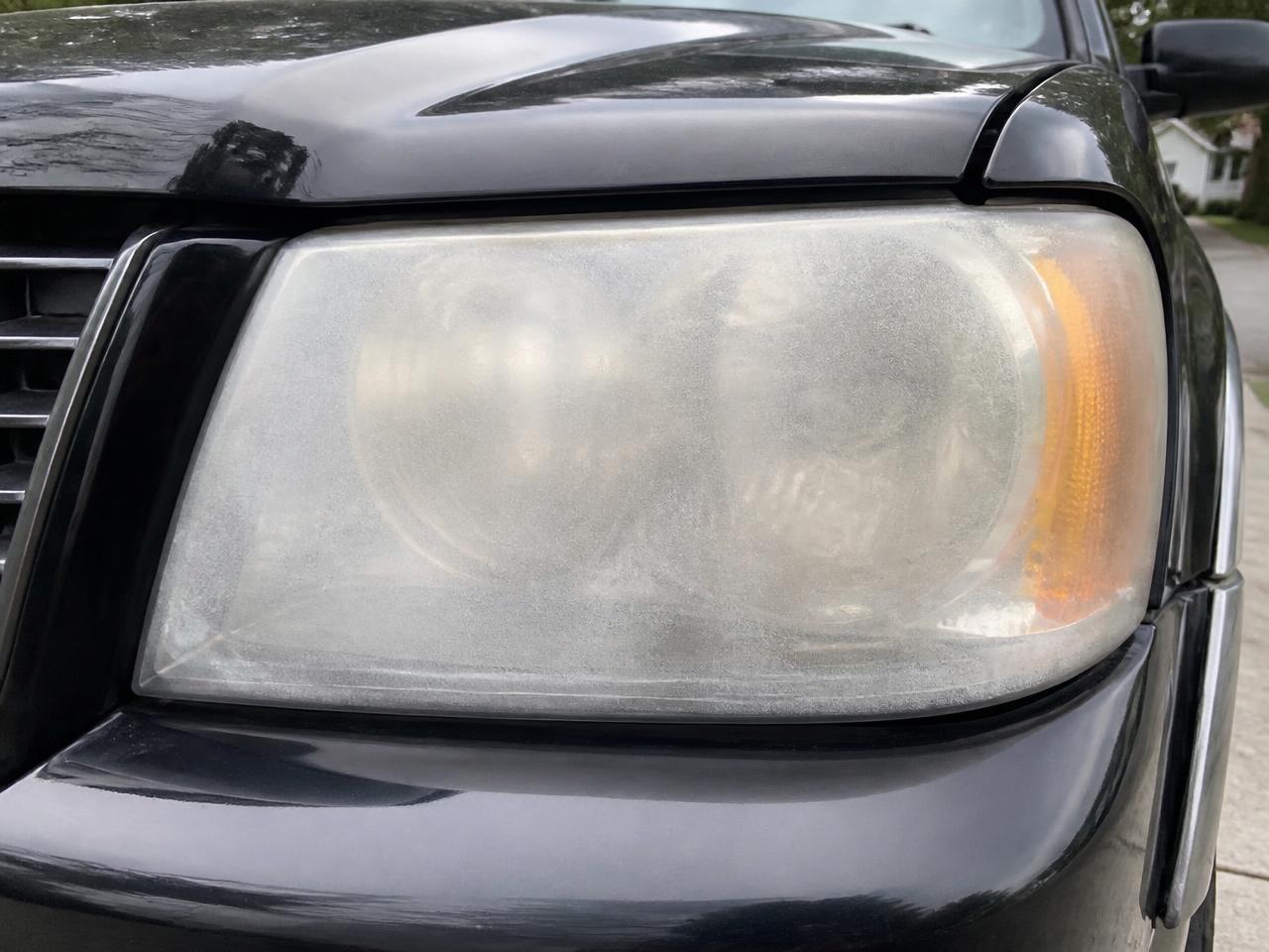 Black SUV — Frisco headlight before restoration — yellowed and oxidized